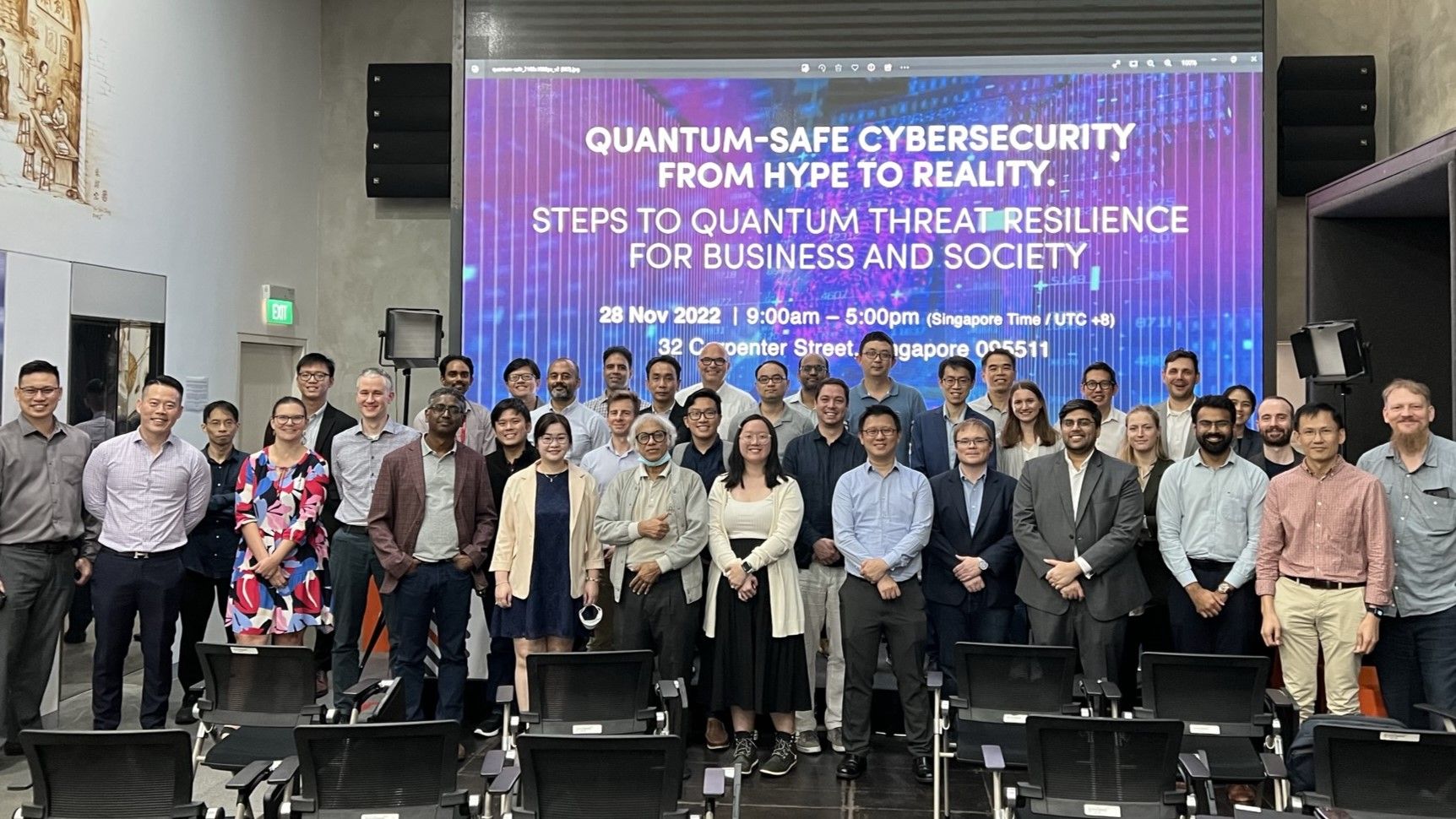 Group photo of delegates at event in front of slide with workshop title "Quantum-Safe Cybersecurity from Hype to Reality-Steps to Quantum Threat Resilience for Business and Society"