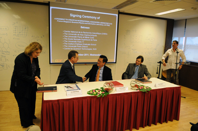 Joel Bertrand of CNRS, Lai Choy Heng of CQT,NUS, and Jorge Tredicce from University of Nice Sophia Antipolis shake hands after signing a research agreement at CQT on 9 November.
