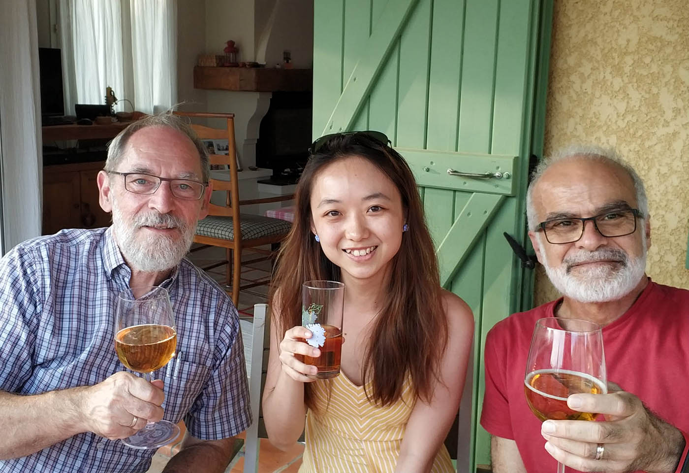 Three quantum scientists sitting with happy smiles and drinks in hand
