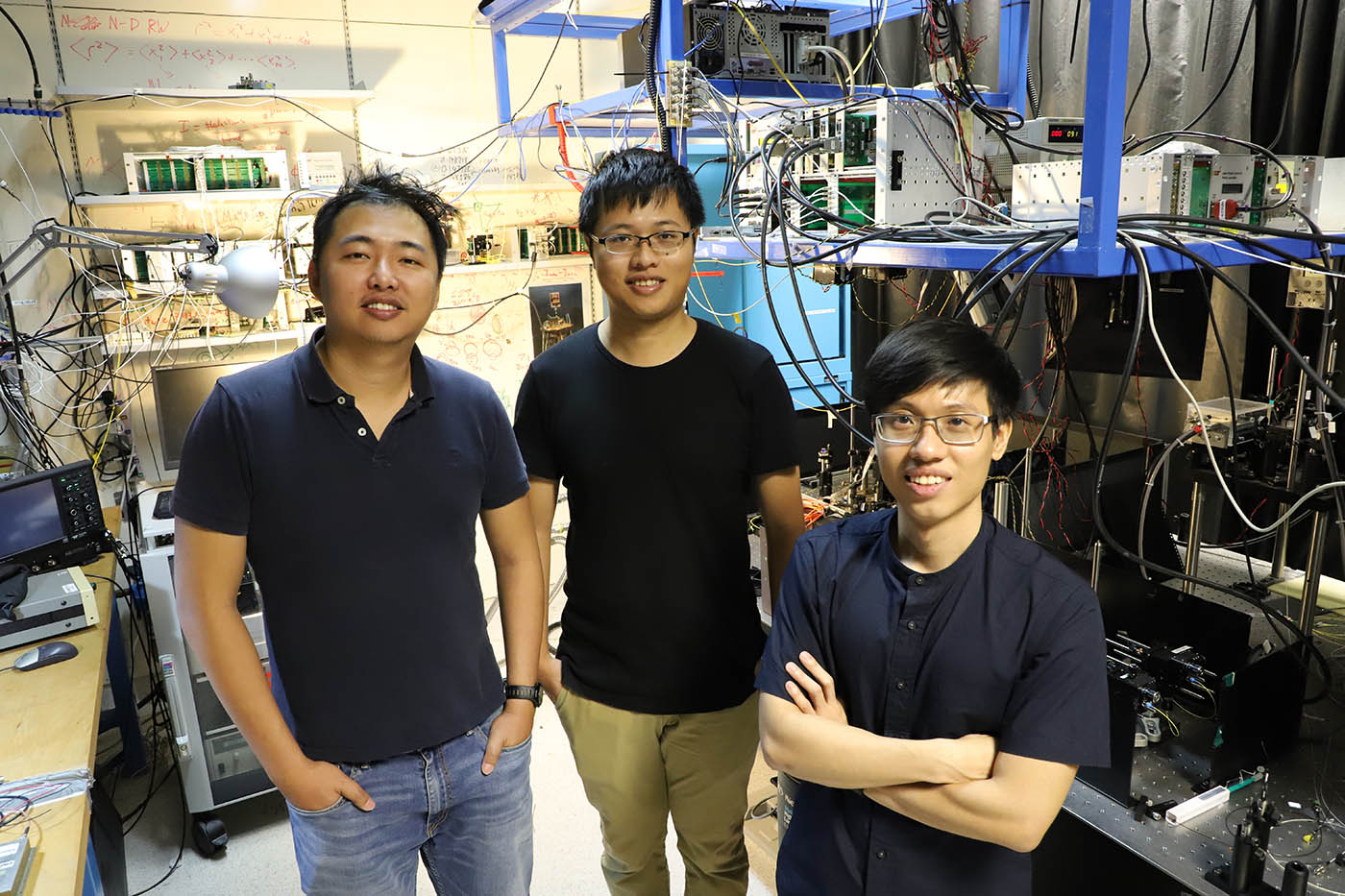 Three researchers in a laboratory at the Centre for Quantum Technologies in Singapore. 